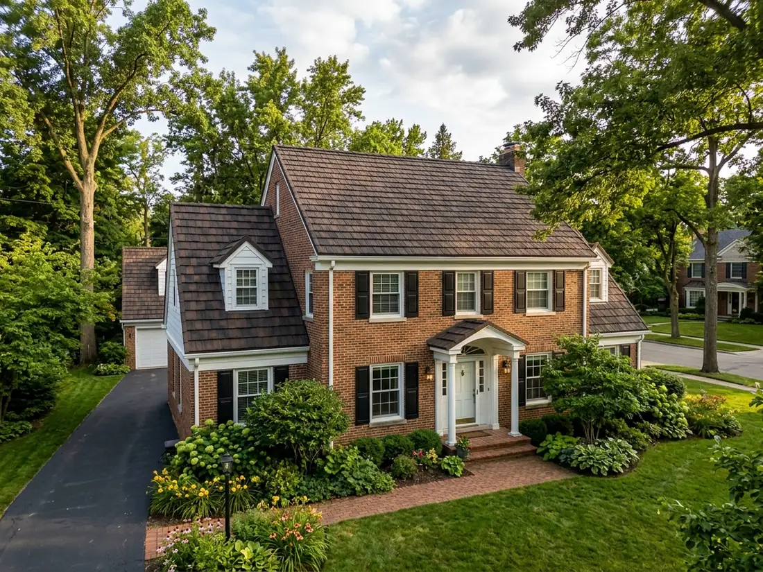 Brown and charcoal stone-coated steel shake panels with thick butt edges on a two-story colonial roof